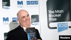 Man Booker Prize 2013 shortlist nominee Colm Toibin poses with his book "The Testament of Mary" during a photo shoot at the Southbank Center in London, October 13, 2013. 