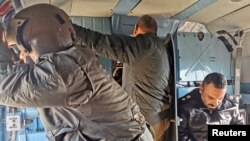 FILE - Iraqi security forces are seen in a helicopter during military operations to search for Islamic State militants in Anbar province, Iraq, Dec. 29, 2019.