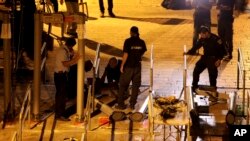 Israeli police officers dismantle metal detectors outside the al-Aqsa Mosque compound in Jerusalem's Old City, July 25, 2017.