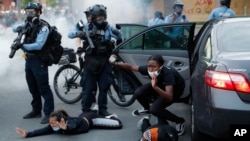 FILE - Motorists are ordered to the ground from their vehicle by police on May 31, 2020, during a protest in Minneapolis over the death of George Floyd, a Black man who died in police custody.