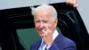 US President Joe Biden crosses his fingers as he responds to a question about the short-term debt deal as he arrives Air Force One at O'Hare International Airport in Chicago, Oct. 7, 2021. 