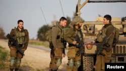 FILE - Israeli soldiers stand near a jeep next to the border fence with the southern Gaza Strip near Kibbutz Nirim, Israel, Feb. 17, 2018.
