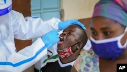 Medical workers from the Ministry of Health wearing protective suits conduct mass-testing of residents in the Eastleigh area of Nairobi, Kenya, May 20, 2020. 