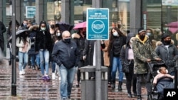 People queue in front of a shop in the city center of Essen, Germany, Dec. 14, 2020.