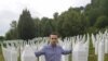 Behidin Piric, a survivor of the Srebrenica Genocide of 1995, stands next to the graves of his grandfather and great-uncles, who were killed in the massacre,while visiting the Srebrenica Memorial Center in Bosnia in 2019. 