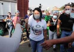 ARCHIVO - La candidata presidencial de Perú, Keiko Fujimori, quien se enfrentará a Pedro Castillo en una segunda vuelta en las elecciones de junio, saluda a sus partidarios en un mercado de frutas y verduras, en Lima. Abril 21 de 2021.