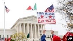 People rally outside the Supreme Court as oral arguments are heard in the case of President Trump's decision to end the Obama-era, Deferred Action for Childhood Arrivals program (DACA), Nov. 12, 2019, at the Supreme Court in Washington. 