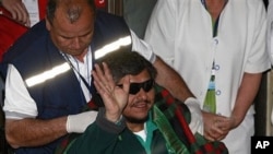 Rescued miner Juan Aguilar waves to the press as he arrives to the hospital in Copiapo, Chile, 14 Oct 2010