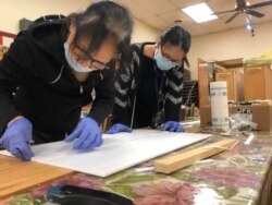 Temple members work on making full-face plastic shields for hospital workers. (Picture was posted on Facebook on April 7). (Photo courtesy of Dinh Tran Tuan)