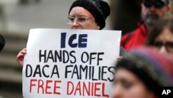 FILE - A protester stands in Seattle, Feb. 17, 2017. A federal judge upheld a decision not to release Daniel Ramirez Medina, a Mexican arrested near Seattle, despite his participation in the DACA program.
