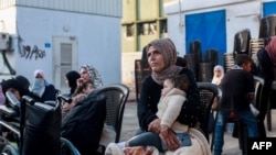 বিশ্ব স্বাস্থ্য সংস্থা ও ফিলিস্তিনি রেড ক্রিসেন্ট গাজার দক্ষিণাঞ্চলের খান ইউনিস থেকে রোগী ও যুদ্ধে আহতদের সরিয়ে নিচ্ছে।গাড়িবহরের অপেক্ষায় রয়েছেন এক নারী ও তার শিশু সন্তান।৬ নভেম্বর, ২০২৪।