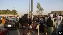 Hundreds of people gather near an evacuation control checkpoint during ongoing evacuations at Hamid Karzai International Airport, in Kabul, Afghanistan, Aug. 25, 2021. 