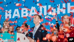 Russian opposition leader Alexei Navalny, right, and his wife Yulia, left, celebrate during a meeting that nominated him for the presidential election race in Moscow, Russia, Dec. 24, 2017.