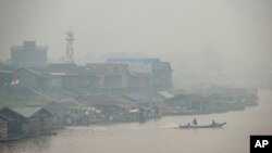 Kabut asap akibat kebakaran hutan menyelimuti pedesaan di sepanjang sungai Kahayan di Palangkaraya, Kalimantan Tengah, 20 September 2019. 