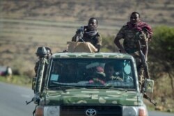 FILE - Ethiopian government soldiers ride in the back of a truck on a road near Agula, north of Mekele, in the Tigray region of northern Ethiopia, May 8, 2021.
