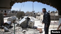 Abu Ghassan, 50, one of the survivors of a chemical attack in the Ghouta region of Damascus that took place in 2013, points at a piece of one of the rockets fired in 2013, as he stands in the Ghouta town of Ain Tarma, Syria, April 7, 2017.