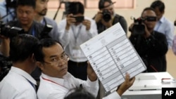 A polling station officer shows a ballot before voting began in the country's general election, at a polling station in Takhmua in Kandal province, southeast of Phnom Penh, Cambodia, July 29, 2018.