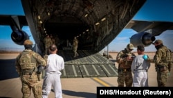 The first U.S. military aircraft to carry detained migrants to a detention facility at Guantanamo Bay, is boarded from an unspecified location in the U.S., Feb. 4, 2025 