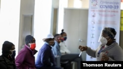 FILE PHOTO: A medical worker talks to volunteers as they wait to receive an injection during the country's first human clinical trial for a potential vaccine against the novel coronavirus, in Soweto.