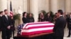 Members of the public walk past Justice Antonin Scalia’s flag-draped coffin inside the Great Hall of the US Supreme Court in Washington, February 19, 2016. (M.Snowiss/VOA)