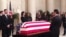 Members of the public walk past Justice Antonin Scalia’s flag-draped coffin inside the Great Hall of the US Supreme Court in Washington, February 19, 2016. (M.Snowiss/VOA)