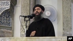 FILE - This still image from video posted on a militant website July 5, 2014, purports to show Islamic State leader Abu Bakr al-Baghdadi delivering a sermon in Iraq.