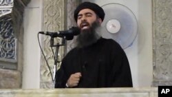FILE - This image from video posted in July 2014 purports to show Islamic State leader Abu Bakr al-Baghdadi delivering a sermon in Iraq.