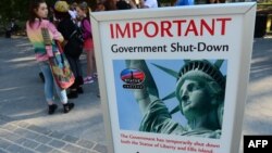 Tourists walk around sign announcing US government shutdown, Oct. 1, 2013. 