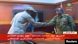 Sudan's General Mohamed Hamdan Dagalo, known as Hemedti, head of the Rapid Support Forces, is sworn-in as the appointed deputy of Sudan's Transitional Military Council, standing before the head of transitional council, Lieutenant General Abdel Fattah al-Burhan