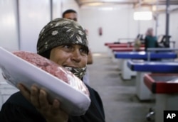 A Syrian refugee woman shops at a supermarket at the Zaatari refugee camp as German Economy Minister Sigmar Gabriel visits the store of the camp near Mafraq, north of Amman, Jordan, Sept. 22, 2015.