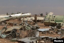 A Syrian Democratic Forces(SDF) fighter walks near destroyed airplane parts inside Tabqa military airport after taking control of it from Islamic State fighters, west of Raqqa city, April 9, 2017.