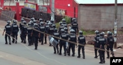 Cameroon police officials walk with riot shields on a street in the administrative quarter of Buea some 60kms west of Douala, Oct. 1, 2017.