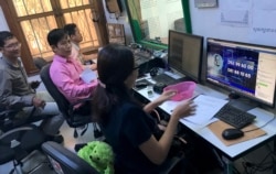 ផលិតករ​ ស្រី សុភ័ក្ត្រ (ឆ្វេង​បំផុត) និង​សហការី​ស្តាប់របស់​អ្នកស្រី​ ឡុង វណ្ណា ​ជំនួយការ​កម្មវិធី​«តុមូល​វីអូឌី»​ ខណៈ​អ្នកស្រី​ប្រុងប្រៀប​ទទួល​ទូរស័ព្ទ​ពី​អ្នក​ស្តាប់​ដែល​ចូល​រួមសួរ​សំណួរ​ក្នុង​កម្មវិធី​នេះ។ (សឹង សុផាត/VOA)