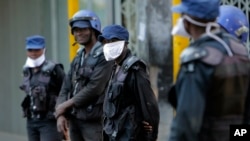 FILE - Riot police wear face masks on the streets of Harare, Zimbabwe, March 31, 2020.