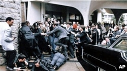 Former White House press secretary James Brady, face down at right, and Washington police officer Thomas Delahanty, front, lie on the ground after being wounded during the assassination attempt on President Reagan March 30, 1981 in Washington.