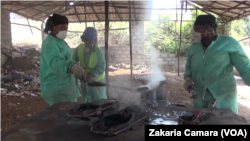 Mariam Keita, directrice de 'Binedou Global Service', et deux de ses employées remplissent les moules, à Conakry, le 5 février 2019. (VOA/Zakaria Camara)