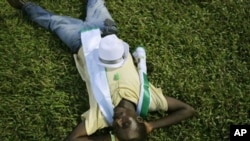 A supporter of opposition candidate Julius Maada Bio naps under stadium lights at rally, Freetown, Sierra Leone, Nov. 15, 2012.