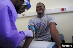 The blood of a survivor of the Ebola virus is extracted as part of a study launched at Liberia's John F. Kennedy Hospital in Monrovia, Liberia, June 17, 2015.