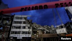 Sisa dari gedung yang runtuh diguncang gempa dan pita merah dengan tulisan "bahaya" terpampang setelah regu penyelamat mengevakuasi jenazah terakhir yang terjebak di dalam reruntuhan bangunan di Mexico City, Meksiko, 4 Oktober 2017. 