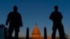 FILE - National Guard members stand their posts around the Capitol at sunrise in Washington, March 8, 2021. 