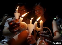 FILE - Pro-democracy supporters hold candles in the shape of "64", which symbolizes "June 4th", during an annual candlelight vigil at Victoria Park in Hong Kong, China, June 4, 2015 to mark Beijing's Tiananmen Square crackdown in 1989.