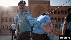 Des policiers déployés après une explosion à l’université islamique au Pakistan, 20 octobre 2009. 