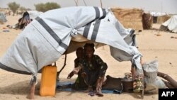 Displaced people fleeing from Boko Haram incursions into Niger are pictured under a makeshift tent in a camp near Diffa on June 16, 2016