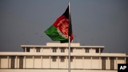 FILE - Afghanistan's flag is seen hoisted before the President House in Islamabad, Pakistan, Nov. 13, 2014, ahead of Afghan President Ashraf Ghani's first state visit to neighboring Pakistan.