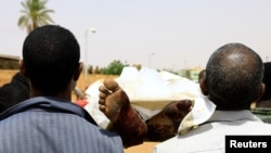 Locals and relatives of three Sudanese men riddled with bullets carry one of the bodies in the city of Omdurman across the River Nile from Khartoum, Sudan, July 1, 2019. 