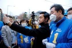 Lee Nak-yon, South Korean former prime minister and a ruling Democratic Party candidate for the parliament, wears a mask to prevent contracting the coronavirus disease as he poses for a selfie in Seoul, April 10, 2020.