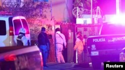 Miembros de un equipo forense caminan cerca de la escena del crimen donde la periodista mexicana Lourdes Maldonado fue asesinada a tiros frente a su casa en la ciudad fronteriza norteña de Tijuana, México, el 23 de enero de 2022.