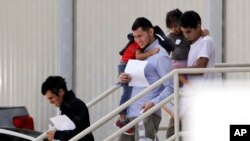 FILE - Immigrant families leave a United States Immigration and Customs Enforcement facility after they were reunited in San Antonio, July 11, 2018.
