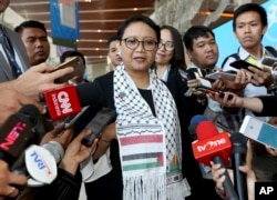 FILE - Wearing a Palestinian scarf, Indonesian Foreign Minister Retno Marsudi, center, talks to the media during Bali Democracy Forum held in Tangerang on the outskirts of Jakarta, Indonesia, Dec. 7, 2017.