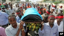 Somali journalists carry the slain body of their colleague, Abdisalan Sheikh Hasan, during his funeral in southern Mogadishu, Somalia, December 19, 2011.